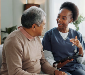 senior sitting and woman holding a tablet