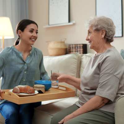 woman giving food to senior