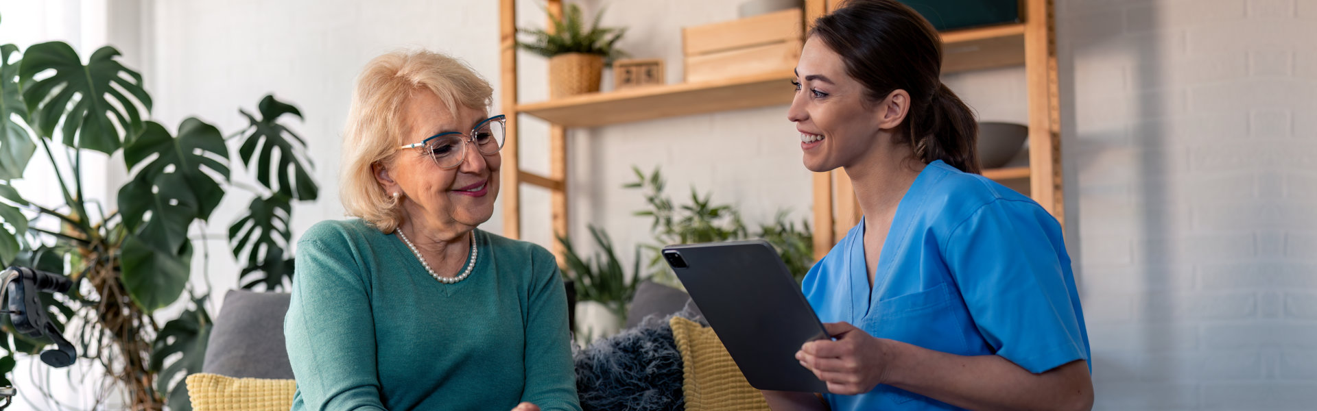 woman holding tablet with senior