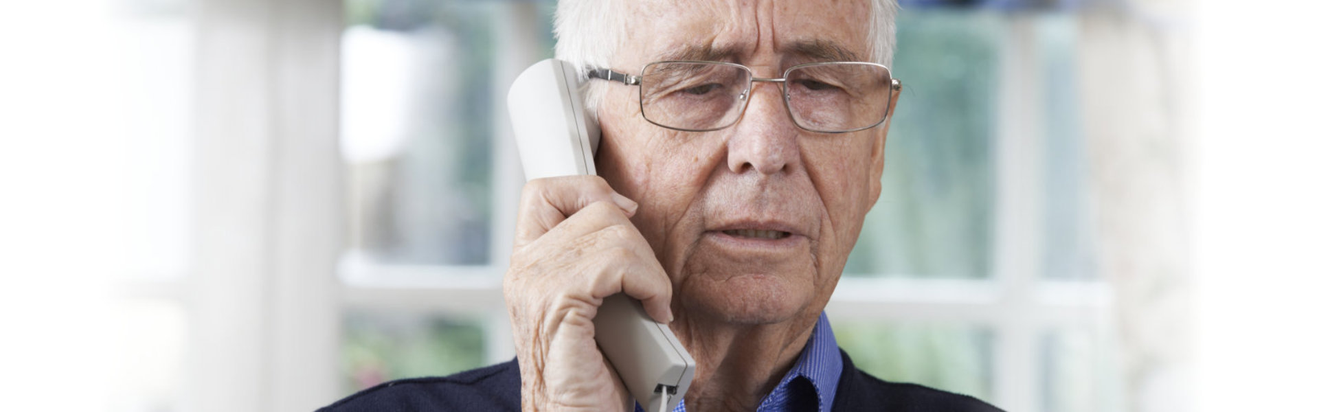 senior holding a telephone